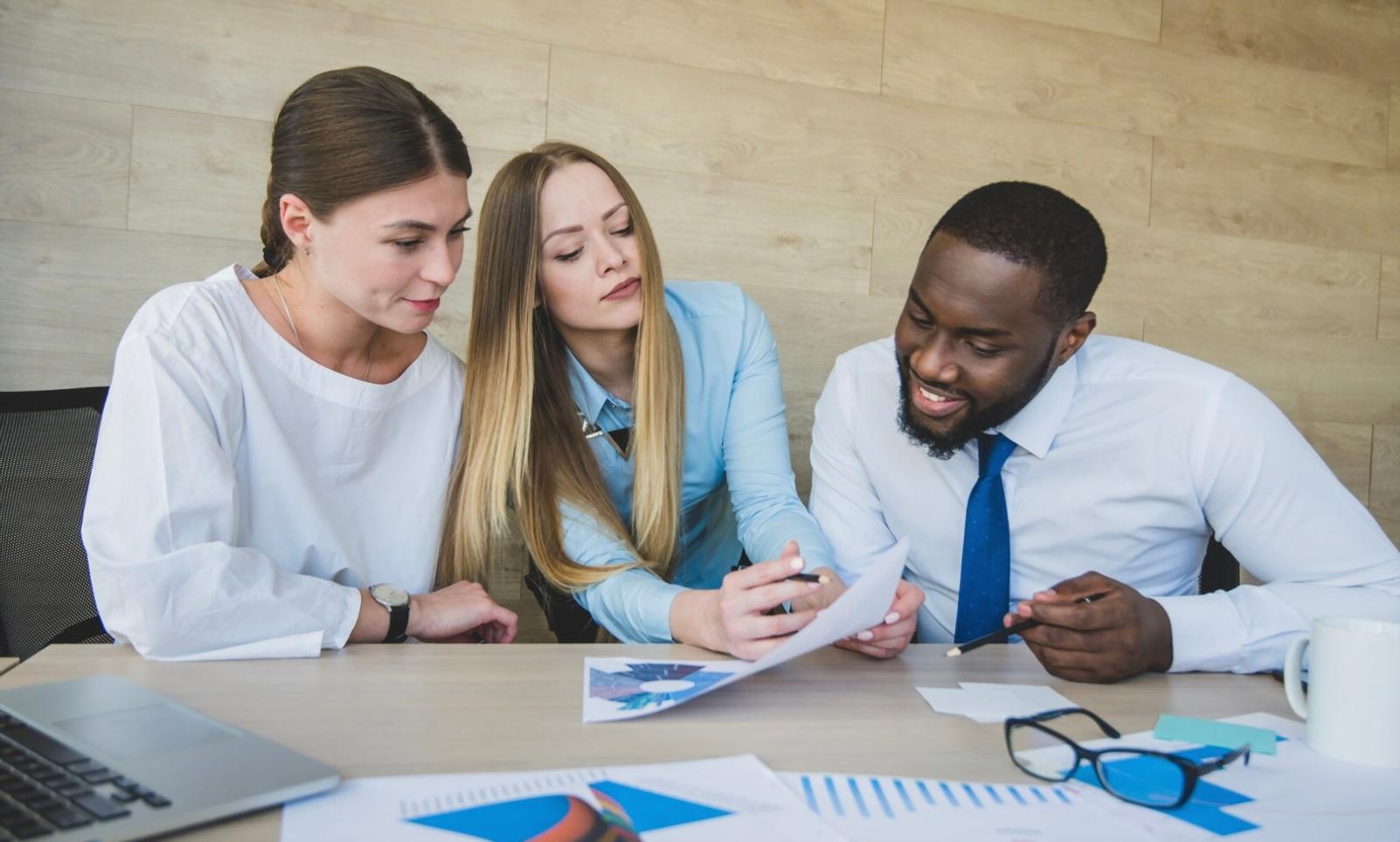 Diverse Gruppe bei gemeinsamer Projektarbeit am großen Tisch